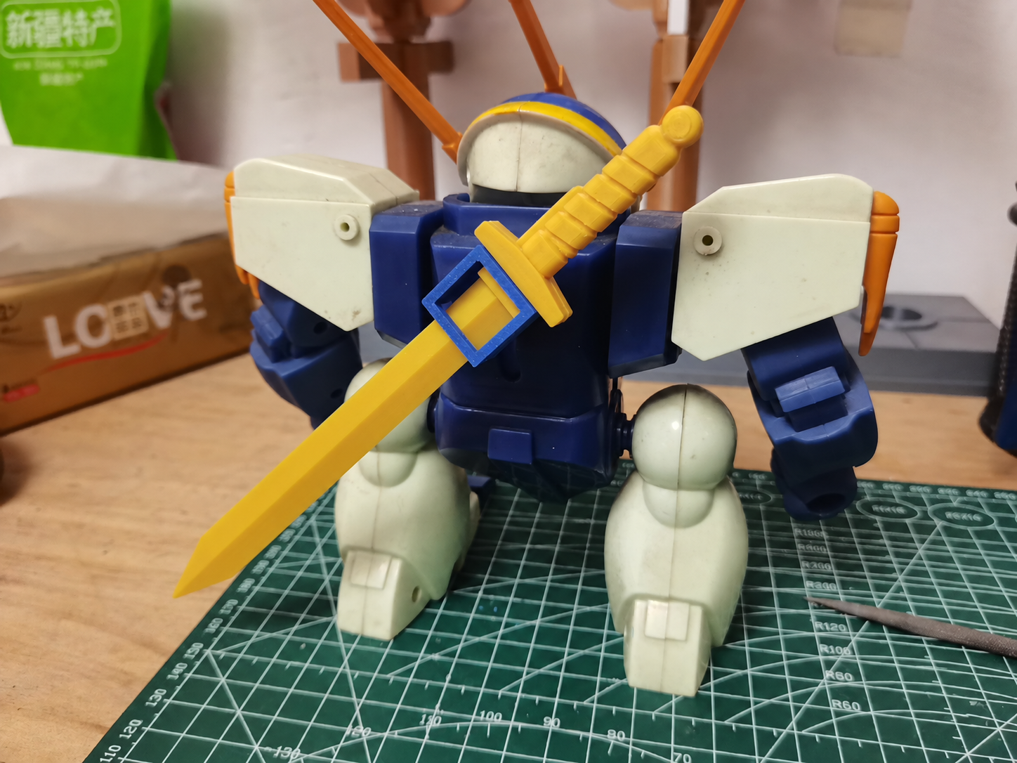 Rear view of a vintage mecha robot with yellow sword mounted on its back